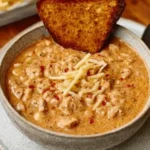 Bowl of creamy white chicken chili with corn, beans, and shredded chicken