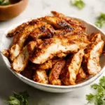 Juicy chipotle chicken served with lime and fresh herbs on a plate