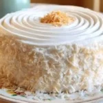 Moist Coconut Cake topped with creamy coconut frosting and shredded coconut