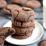 Stack of Chewy Mexican Hot Chocolate Cookies dusted with cinnamon sugar on a wooden board.