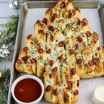 Golden Christmas Tree Pull-Apart Bread brushed with garlic butter and sprinkled with herbs.