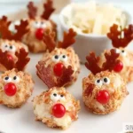 Reindeer-shaped cheeseballs decorated with pretzel antlers, olive eyes, and red candy noses.